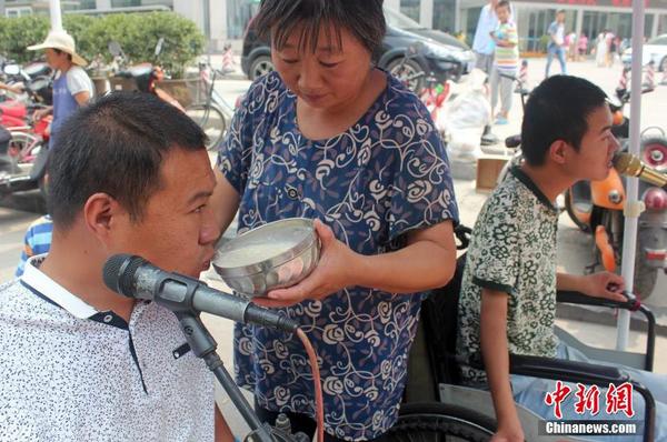 每天起床后便匆匆來到街頭“賣唱”，呂愛梅只能把面湯熬好在小強和小猛唱歌間隙喂他們吃。馬義恒 攝