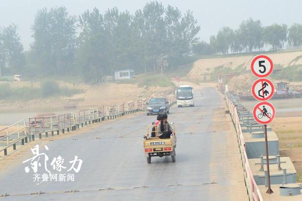 濟南北店子黃河浮橋兩側也設有提示牌，禁止自行車上橋，一輛三輪車慢慢駛向對岸。（圖文 李瑞平）