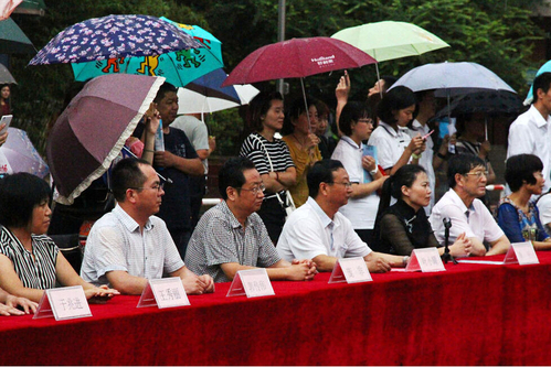 在主席臺上觀看的校領導也堅持不打傘陪學生一起淋雨，身旁站滿了打傘觀看的家長。