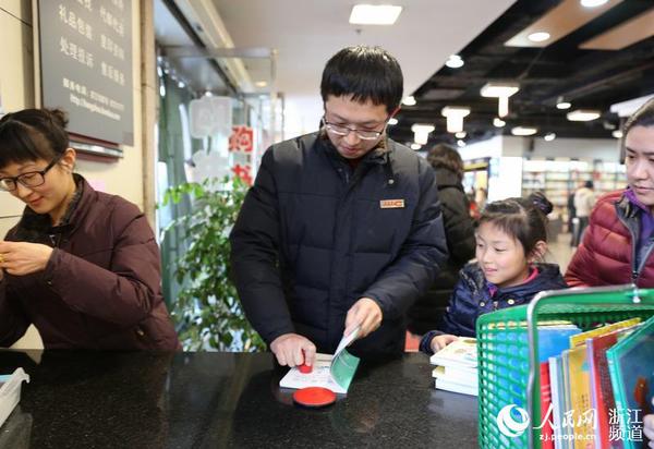 圖書管理員給新書加蓋杭州圖書館公章。