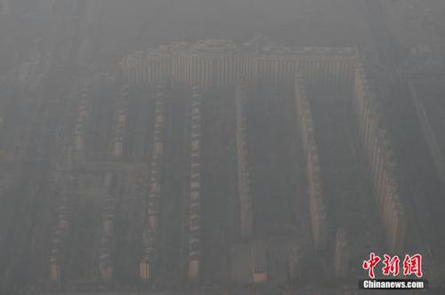 資料圖：2015年12月21日，北京上空航拍空氣重污染，地面建筑若隱若現。12月18日，北京再次發布紅色預警，12月19日7時至12月22日24時啟動空氣重污染紅色預警措施。實施機動車單雙號行駛、建議中小學幼兒園停課等措施。 <a target='_blank' href='http://www.chinanews.com/'>中新社</a>記者 廖攀 攝