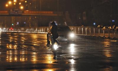 昨日，大望路，行人正在冒雨過人行道。 新京報記者 王飛 攝