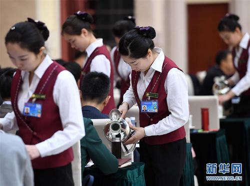 3月6日，北京華北賓館的女服務員在民盟、無黨派人士界委員聯組會上倒水。在兩會會場內外，女代表、女委員、女工作人員、女記者在工作中盡職盡責，展現著自己的風采。 新華社記者張鐸攝