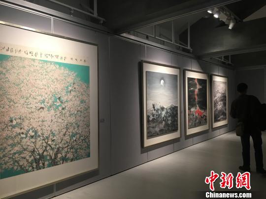 “彩·墨之境——鄧建強作品展”現場，觀眾在《春上暖陽》等四幅作品前駐足觀賞。　劉賢　攝