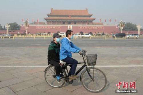 資料圖：一對(duì)青年佩戴口罩騎車經(jīng)過北京天安門廣場(chǎng)。 <a target='_blank' href='http://www.chinanews.com/'>中新社</a>記者 崔楠 攝