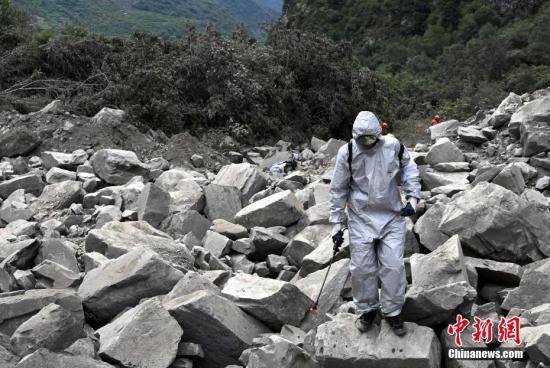 6月26日，四川茂縣疊溪鎮新磨村新村組富貴山“6·24”特別重大山體滑坡災害搜救工作進入第3天，上千名救援人員堅守現場全力搜救。圖為防疫人員進行消毒防疫。 中新社記者 安源 攝