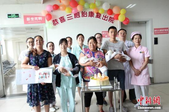 圖為醫護人員和三胞胎及家人合影。 鐘欣 攝
