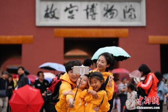 10月2日，北京小雨，游客在故宮博物院游覽。根據國家旅游局數據中心綜合測算，中國國慶假期首日，全國當天共接待游客1.13億人次，同比增長10.5%，實現旅游收入965億元，同比增長12.2%。<a target='_blank' href='http://www.chinanews.com/'>中新社</a>記者 杜洋 攝