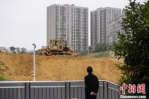 資料圖：市民觀望一樓盤工地上的推土機作業。<a target='_blank' href='http://www.chinanews.com/'>中新社</a>記者 楊華峰 攝