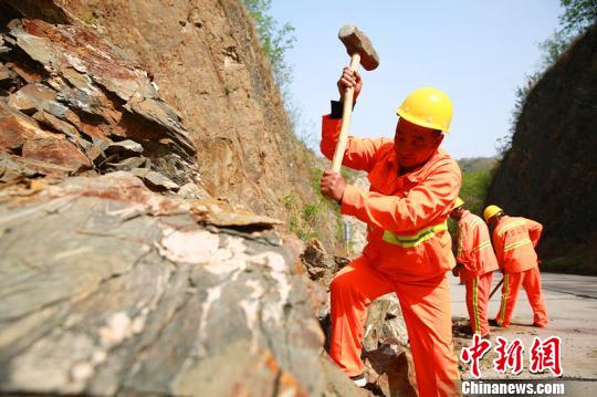 楊衛(wèi)東帶領(lǐng)工友們正在清理落石。　劉繼東 攝