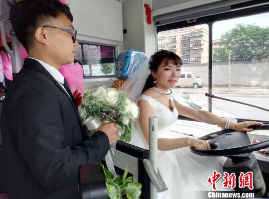 李金可駕駛公交車行駛，丈夫手捧鮮花守護(hù)在側(cè)。　朱幸 攝