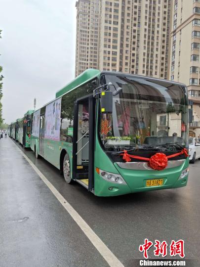 六輛公交車做婚車，新人們用實(shí)際行動(dòng)詮釋“綠色出行”。　朱幸 攝