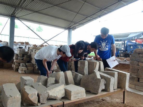 圖7 中國人民大學研究生在曹魏大墓工地現場考察出土墓磚（李重蓉攝影）