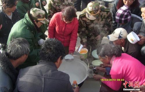 官兵在營地與災民共同吃飯。武警玉樹支隊 趙飛 供圖