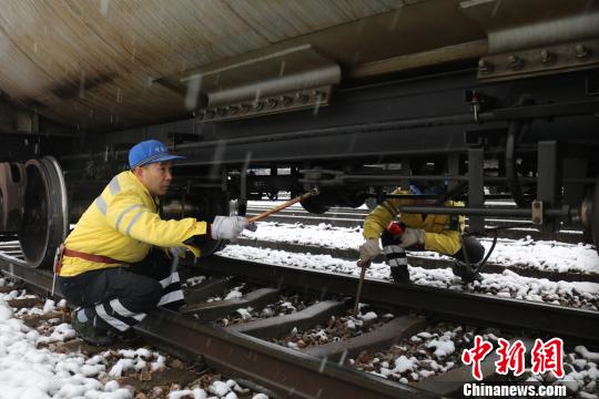 南京東車輛段貨車檢車員風(fēng)雪里按標(biāo)準(zhǔn)作業(yè)，保障運(yùn)輸安全。　劉寅 攝