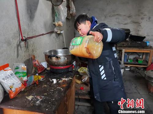 當天中午，劉奉智熟練地切白菜、刷鍋、燒油，燉白菜湯，準備午飯。　郝學娟 攝