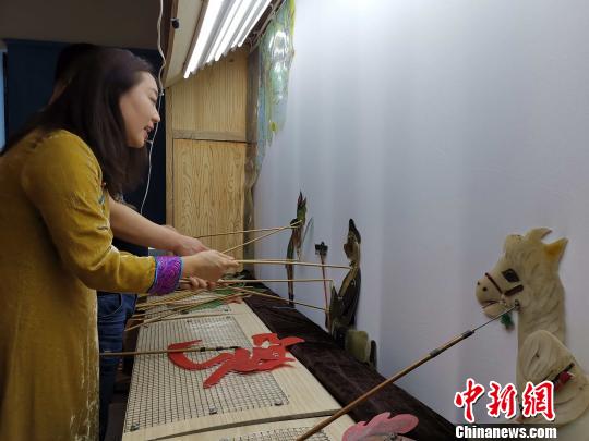 李娟藏在幕布后，繪聲繪色地為觀眾表演《西游記之孫悟空大戰蝎子精》。　趙曉 攝