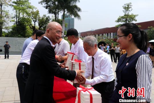 李德文董事長給學校老師贈送《論語新解》。　魏玥 攝