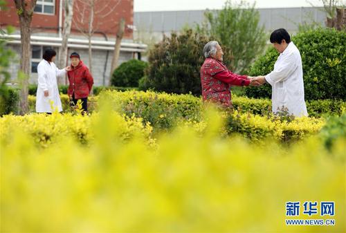 5月5日，在河北省衡水市桃城區一家養老康復醫療中心，護工在陪老人散步。新華社記者 牟宇 攝