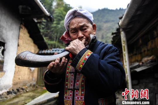 盡管年過八旬，盤良安依舊能吹響牛角迎客。　李凌 攝