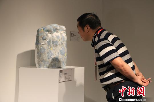 9月20日，第十三屆全國(guó)美術(shù)作品展覽陶藝作品展作品吸引觀者駐足觀賞。　李韻涵 攝