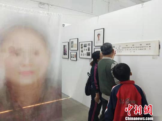 在第19屆中國平遙國際攝影大展柴油機(jī)展區(qū)的一角，一張大幅的人像彩畫吸引來往游客駐足拍照。　楊佩佩 攝