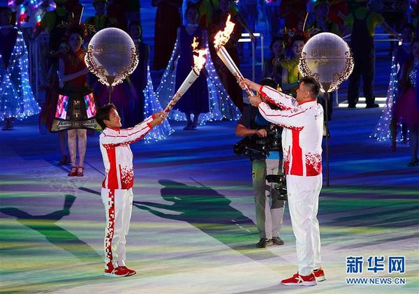 10月18日，第七屆世界軍人運(yùn)動(dòng)會(huì)開幕式在武漢體育中心舉行。這是火炬手王霜（左）與火炬手劉玉棟在開幕式上交接。新華社記者 金良快 攝