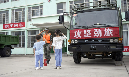 圖為在學(xué)校宿營(yíng)點(diǎn)，小學(xué)生向抗洪官兵官兵敬禮表達(dá)謝意的畫(huà)面。（付少旋）