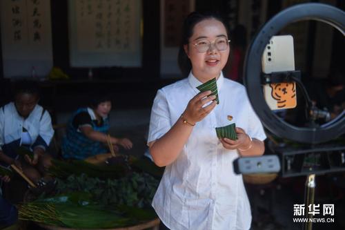 6月8日，湖源鄉的青年黨員志愿者通過直播帶貨的形式為特色灰湯粽擴大知名度。新華社記者 徐昱 攝