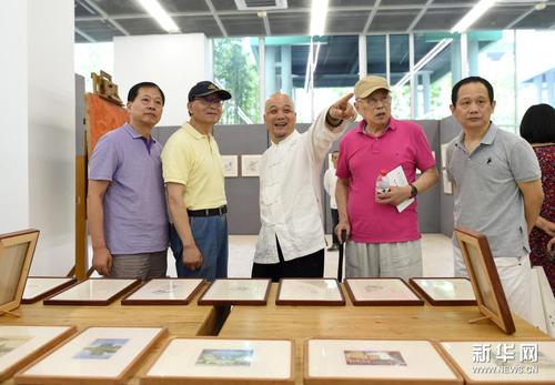 7月10日，國家級非物質文化遺產代表性傳承人、杭州十竹齋藝術館館長魏立中（左三）向嘉賓介紹參展作品。新華社記者 韓傳號 攝